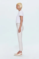 Person wearing a white t-shirt and white pants on a light blue background