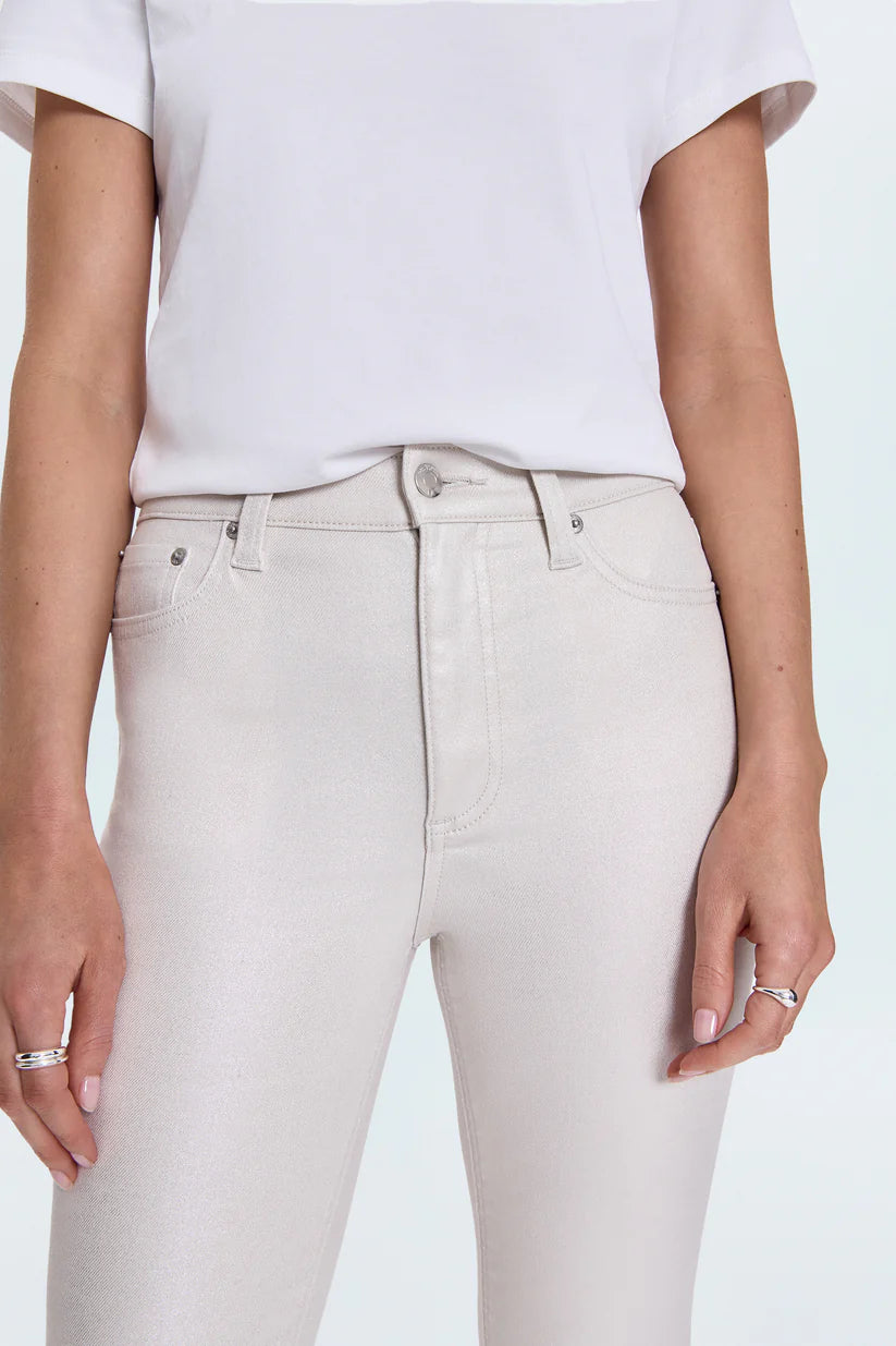 Person wearing light gray jeans and a white top on a light blue background