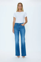 Woman wearing a white t-shirt and blue jeans on a white background