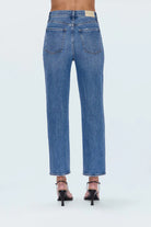 Blue jeans worn by a person on a white background