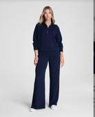 Woman wearing a navy blue outfit on a white background