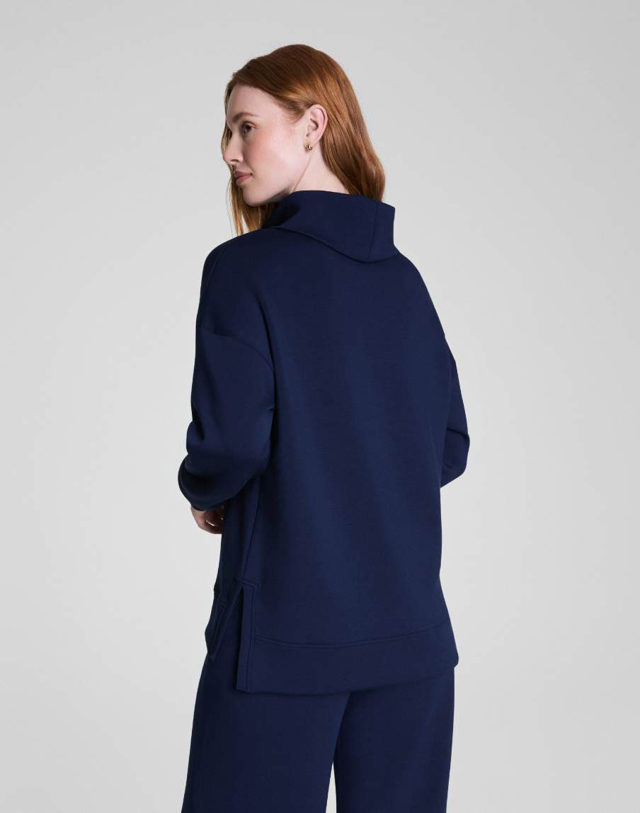 Woman wearing a navy blue suit on a light gray background