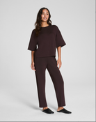 Woman wearing a brown outfit on a white background