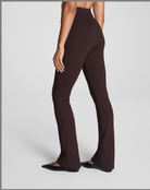 Brown flared pants worn by a person on a light gray background