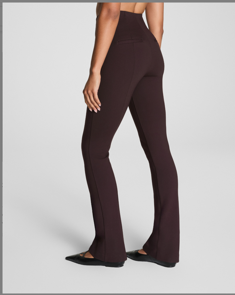 Brown flared pants worn by a person on a light gray background