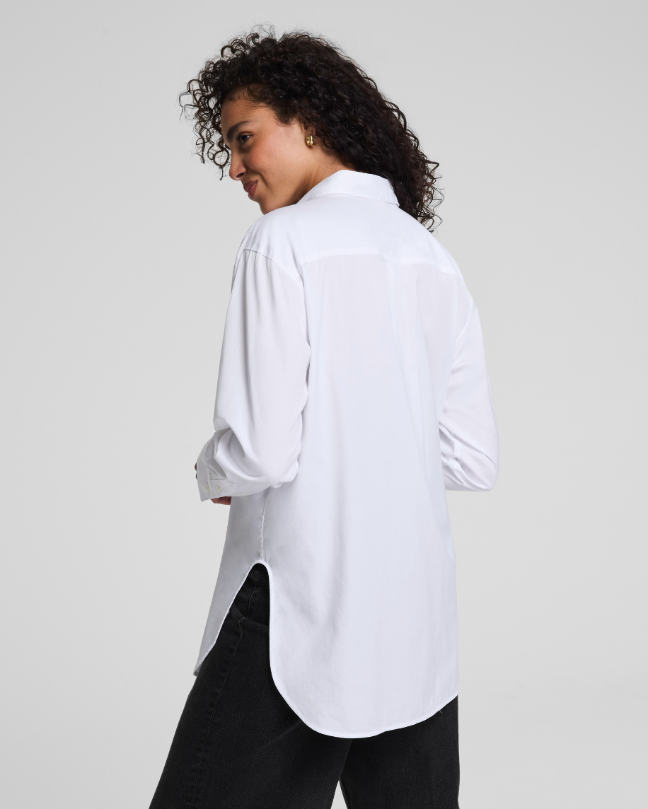 Person wearing a white shirt and black pants on a plain background