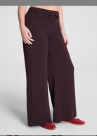 Dark brown wide-leg pants worn by a person on a light gray background