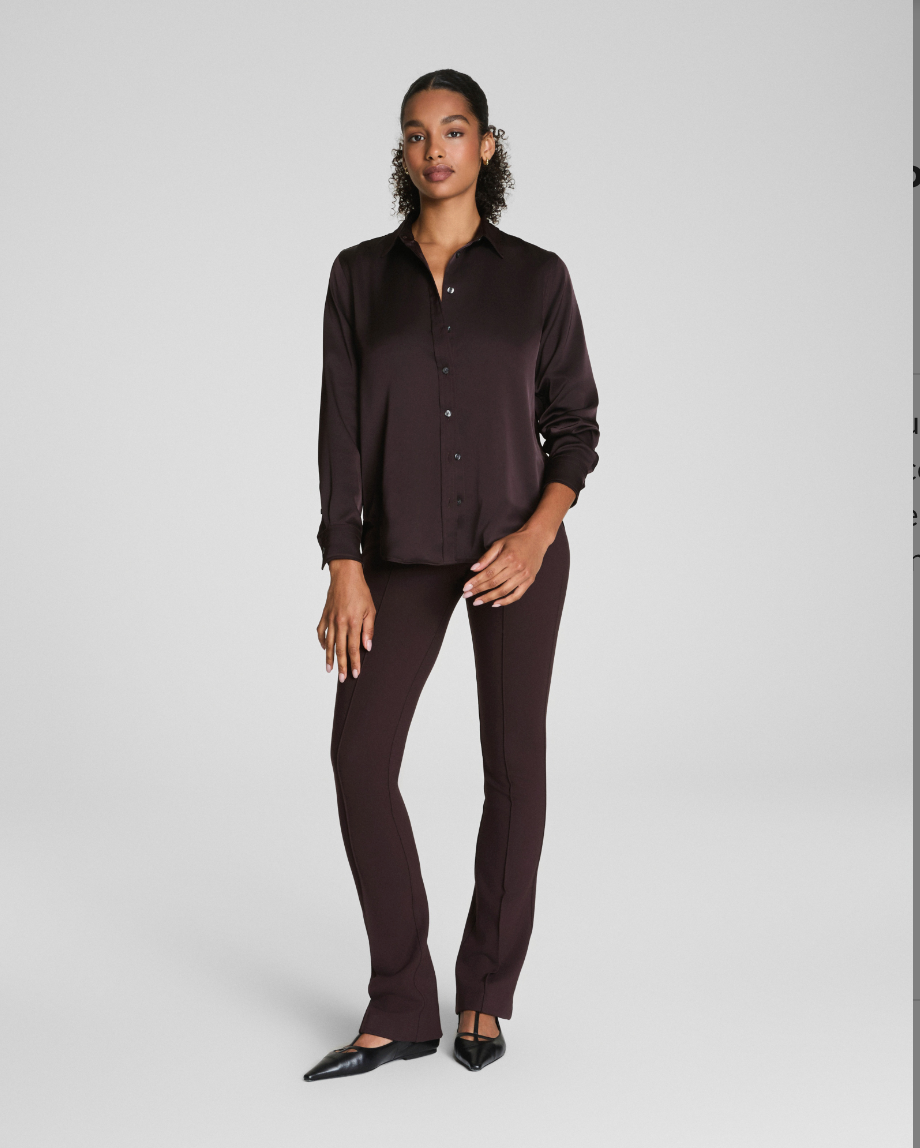 Woman wearing a dark brown shirt and pants on a white background