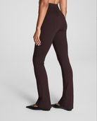 Brown high-waisted pants worn by a person on a light gray background