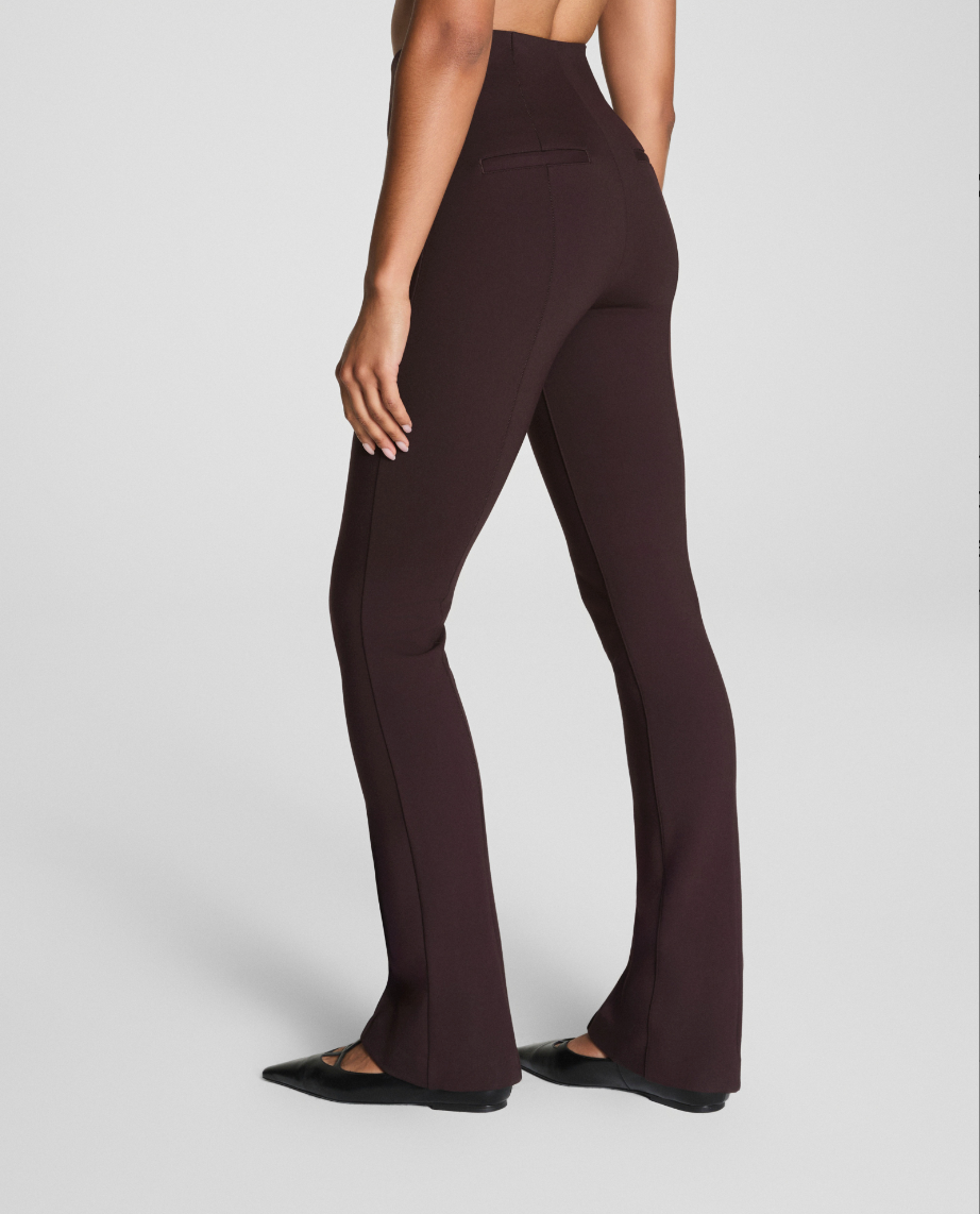 Brown high-waisted pants worn by a person on a light gray background
