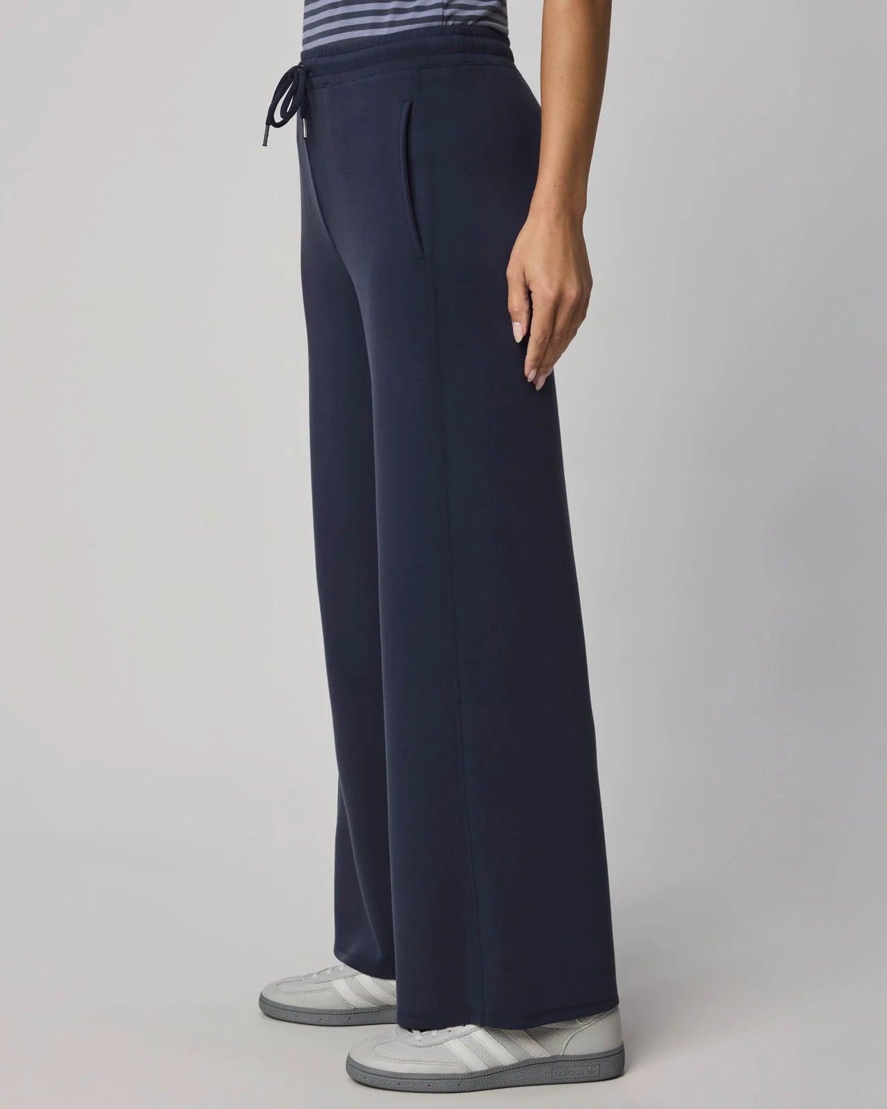 Navy blue pants worn by a person on a gray background