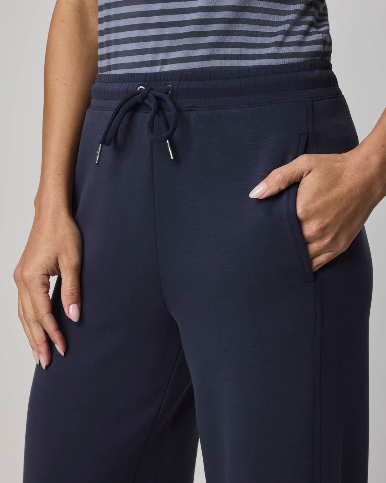 Navy blue pants worn by a person on a gray background