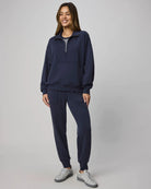 Woman wearing a navy tracksuit with a white background