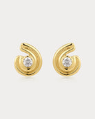 Gold earrings with diamond centers on a light gray background