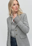 Woman wearing a gray coat on a plain background